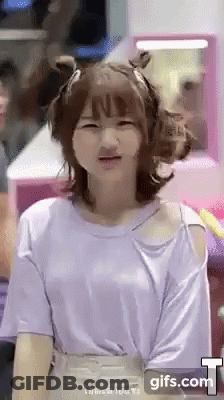 A Girl Wearing A Purple Shirt Is Making A Face . GIF