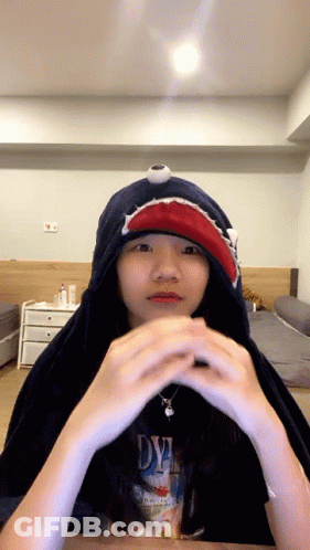 A Girl Wearing A Shark Hoodie And A Dye Shirt GIF