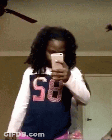 A Girl Wearing A Shirt With The Number 58 On It Takes A Selfie With Her Phone GIF