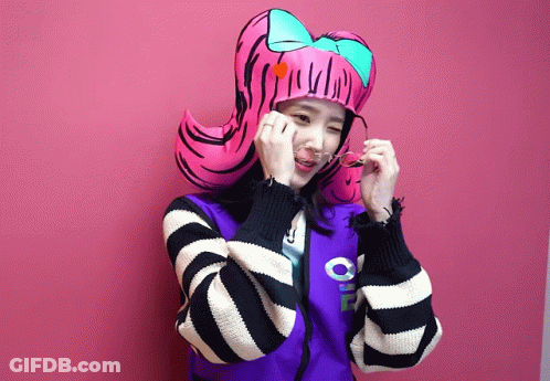 A Girl Wearing A Striped Jacket And A Pink Hat With A Bow GIF
