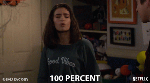 A Girl Wearing A Sweater That Says Good Vibes Blows A Kiss GIF
