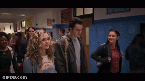 A Girl Wearing A T-Shirt That Says Powerful Shine Is Walking Down A Hallway GIF