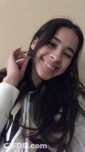 A Girl Wearing A White Sweatshirt With The Letter W On It Smiles For The Camera GIF