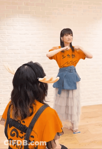 A Girl Wearing An Orange Shirt That Says シカ 部 GIF