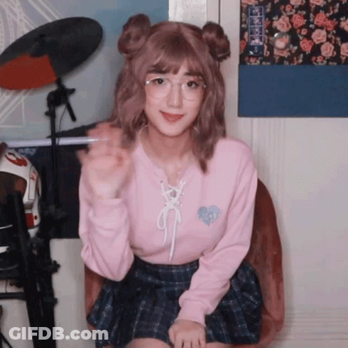A Girl Wearing Glasses And A Pink Sweater With A Heart On The Front GIF
