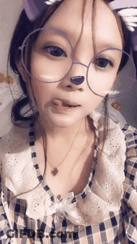 A Girl Wearing Glasses And A Plaid Shirt Has A Purple Nose GIF