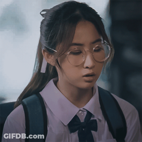A Girl Wearing Glasses And A White Shirt With A Black Bow GIF