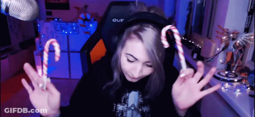 A Girl Wearing Headphones Holds Up Two Candy Canes In Front Of A Microphone GIF