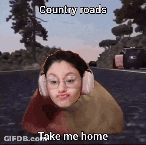 A Girl Wearing Headphones Is Laying On A Road With The Caption Country Roads Take Me Home . GIF