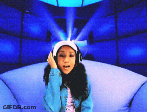 A Girl Wearing Headphones Is Sitting In A Chair GIF