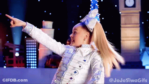 A Girl With A Bow In Her Hair Is Pointing At Something In Front Of A Big Ben GIF