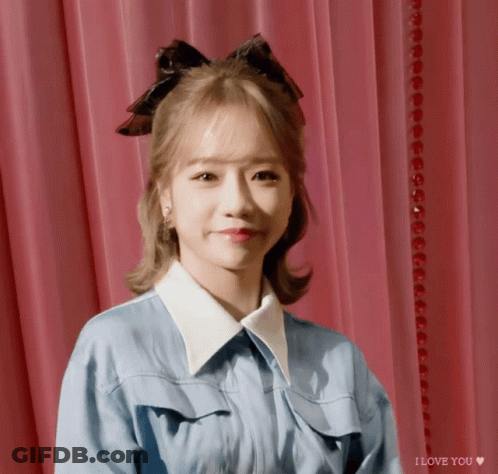 A Girl With A Bow In Her Hair Says I Love You On The Bottom GIF