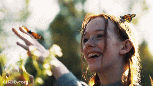 A Girl With A Butterfly On Her Head Looks Up At The Sky GIF