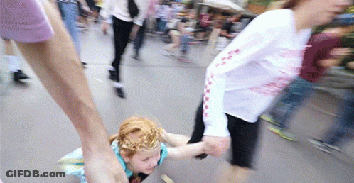 A Girl With A Crown On Her Head Is Being Held By A Woman GIF