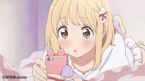 A Girl With A Flower In Her Hair Is Laying On A Bed And Looking At Her Phone GIF