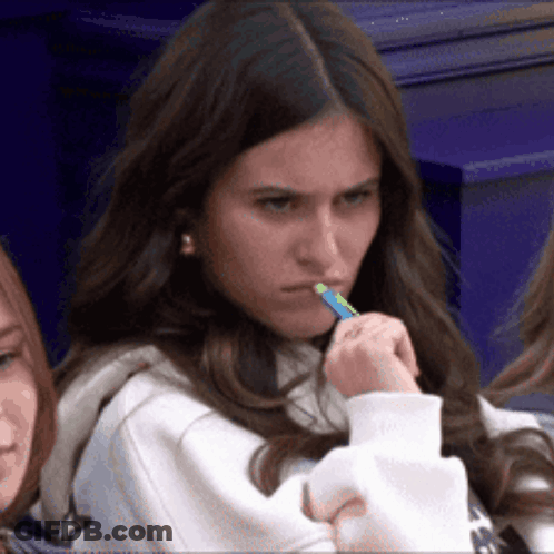 Girl With Green Pen In Mouth Looking At Camera GIF