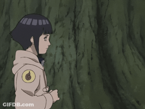 A Girl With A Hooded Jacket Is Standing In Front Of A Tree With Her Hands Together GIF
