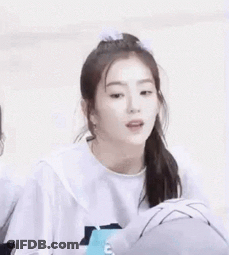 A Girl With A Ponytail And A Bow In Her Hair Is Wearing A White Shirt . GIF