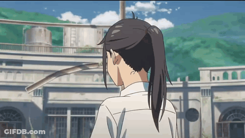 A Girl With A Ponytail Stands In Front Of A Large Building GIF