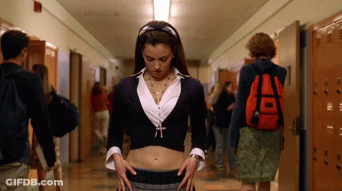 A Girl With A Red Backpack Is Standing In A Hallway With Other People GIF