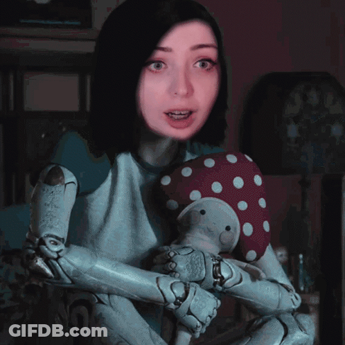 A Girl With A Robotic Arm Is Holding A Stuffed Animal GIF