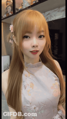 A Girl With Blonde Hair And A Floral Dress GIF