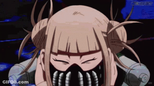 A Girl With Blonde Hair And A Mask On Her Face Looks At The Camera With Her Eyes Closed GIF