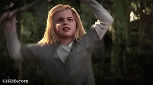 A Girl With Blonde Hair And A White Shirt Is Holding Her Head In The Air GIF