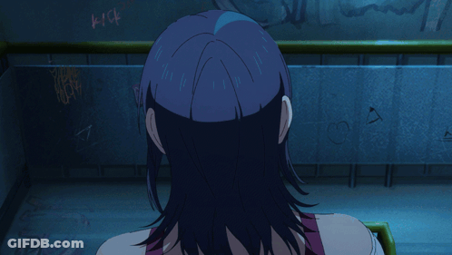 A Girl With Blue Hair Is Screaming In Front Of A Wall That Has Graffiti On It GIF