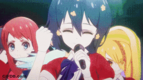 A Girl With Blue Hair Is Singing Into A Microphone In Front Of Two Other Girls GIF