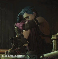 A Girl With Blue Hair Is Sitting On A Table With Her Head On Her Knees GIF