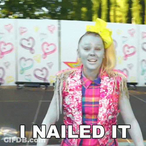 A Girl With Blue Paint On Her Face Is Standing In Front Of A Wall That Says I Nailed It . GIF