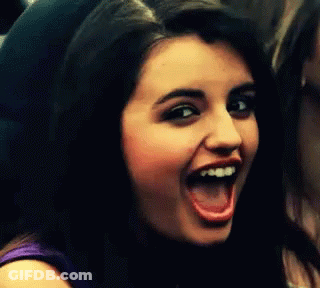 A Girl With Braces On Her Teeth Is Smiling With Her Mouth Open GIF