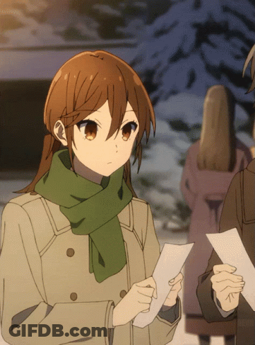 A Girl With Brown Hair And A Green Scarf Holds A Piece Of Paper GIF