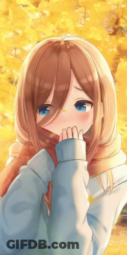 A Girl With Brown Hair And Blue Eyes Is Covering Her Face With A Scarf GIF