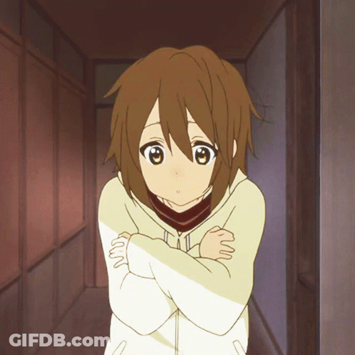 A Girl With Brown Hair Is Standing With Her Arms Crossed In A Hallway GIF