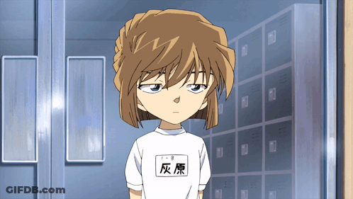 A Girl With Chinese Writing On Her Shirt Is Standing In Front Of A Row Of Lockers GIF