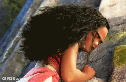 A Girl With Curly Hair Is Laying On A Rock With Her Eyes Closed GIF
