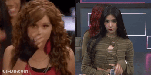 A Girl With Curly Hair Is Standing Next To Another Girl GIF