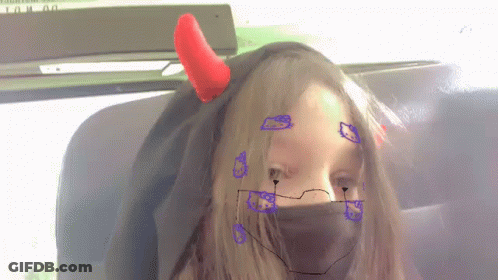 A Girl With Devil Horns On Her Head And A Hello Kitty Face Mask GIF