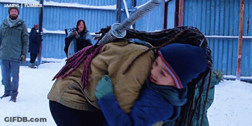 A Girl With Dreadlocks Is Hugging A Boy In The Snow GIF