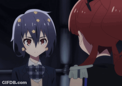 A Girl With Flowers In Her Hair Looks At Another Girl With Red Hair GIF
