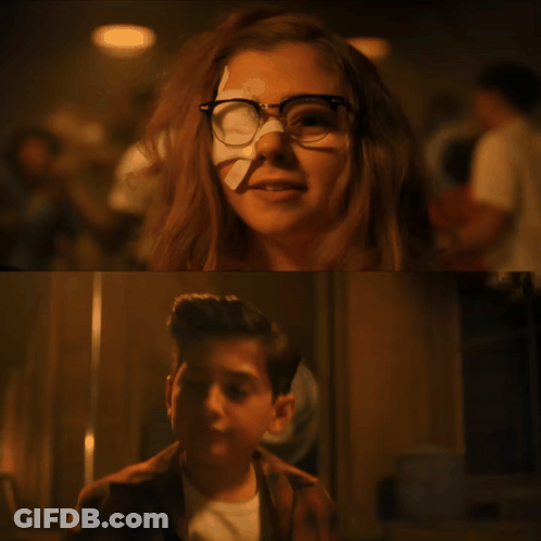 A Girl With Glasses And A Bandage On Her Nose Is Next To A Boy Holding A Stick GIF