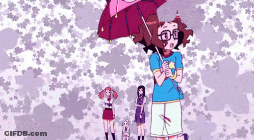 A Girl With Glasses Is Holding An Umbrella In Front Of A Pattern Of Flowers GIF