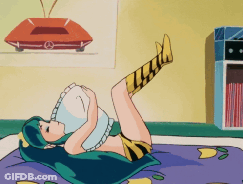 A Girl With Green Hair Is Laying On Her Stomach With Her Legs Up GIF
