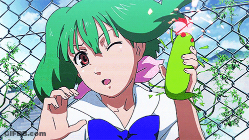 A Girl With Green Hair Is Standing In Front Of A Chain Link Fence Holding A Green Object GIF