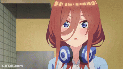 A Girl With Headphones Around Her Neck Is Looking At Something GIF