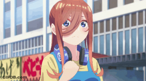 A Girl With Headphones Around Her Neck Is Standing In Front Of A Building GIF