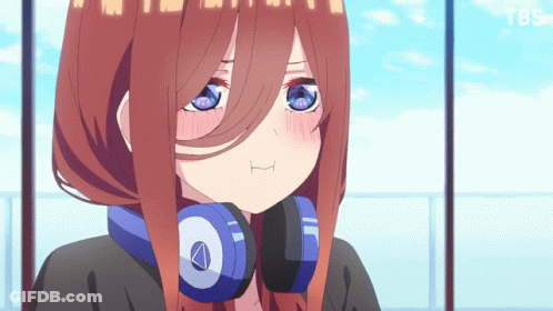 A Girl With Headphones Around Her Neck Looks At The Camera GIF