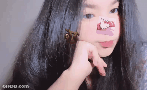 A Girl With Hello Kitty Stickers On Her Face GIF